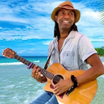 Carlos Trapp playing guitar on the beach